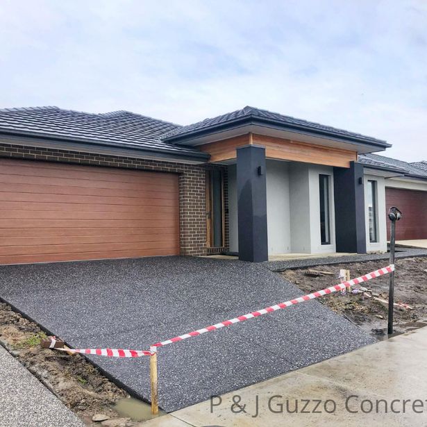 Side angle for house driveway with exposed aggregate finish in the process of drying